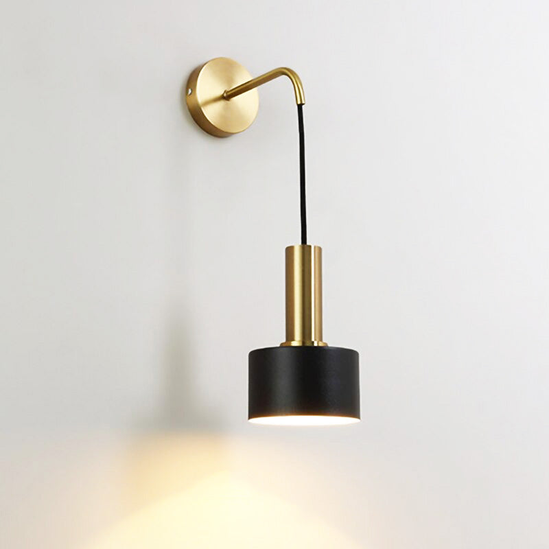 Applique murale dorée, bras élégant, abat-jour noir cylindrique diffusant lumière ciblée vers le bas.