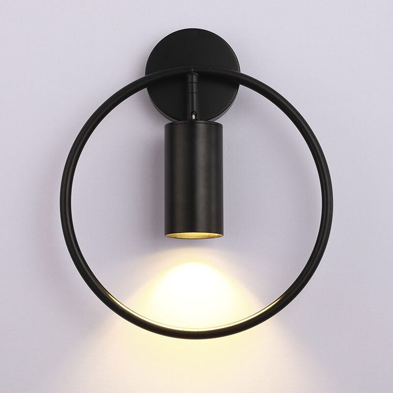 Applique murale noire moderne, cercle et cylindre pivotant, éclaire doucement le mur.