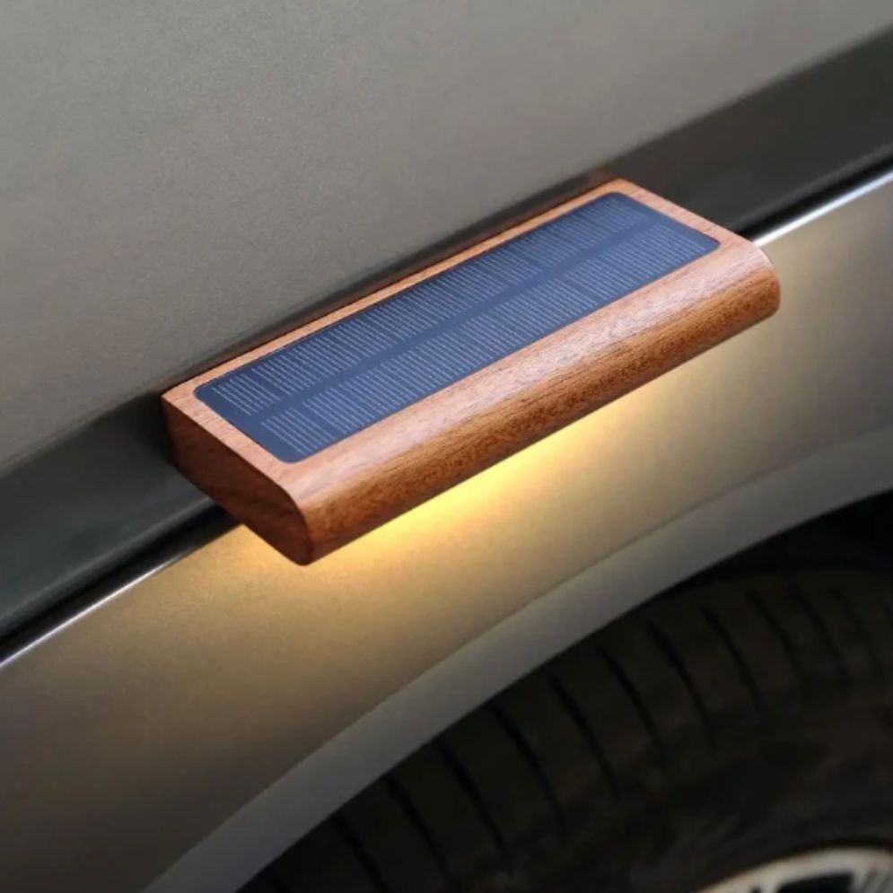 Applique murale bois solaire LED forme élancée diffusant une lumière jaune chaleureuse.