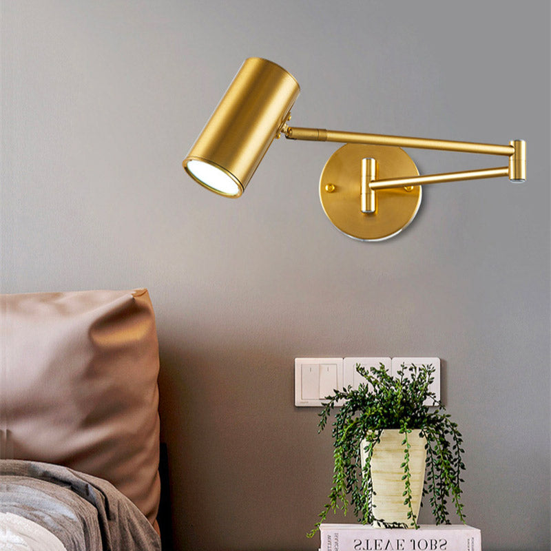 Applique murale dorée en aluminium au design épuré, fixée sur mur gris.